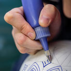 Rhian Malin decorating a mandala bottle in her workshop 2019